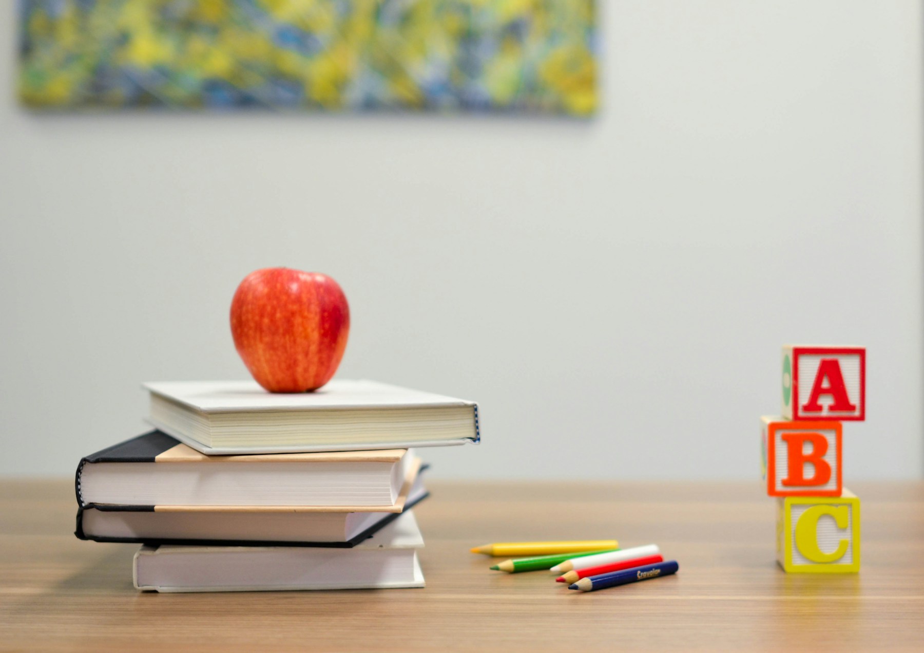 School books, coloured pencils and ABC blocks on a desk